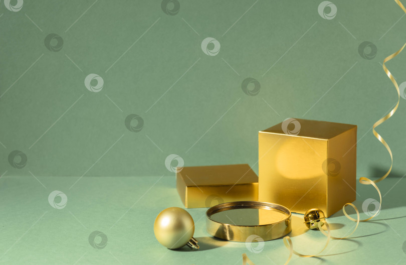 Скачать Золотой подиум с рождественскими шарами и коробкой для демонстрации подарка. Зеленый фон с копией места для презентации бренда и упаковки фотосток Ozero