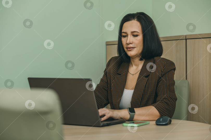 Скачать деловая женщина, пользующаяся ноутбуком в офисе. Предприниматель малого бизнеса. Место для копирования фотосток Ozero