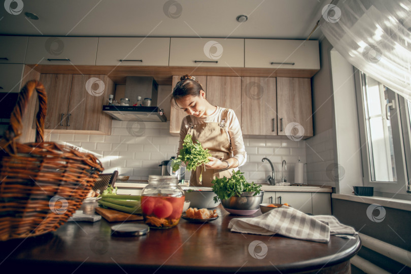 Скачать Руки молодой женщины выкладывают тыкву на сковороду для запекания на кухне. Концепция здорового питания фотосток Ozero