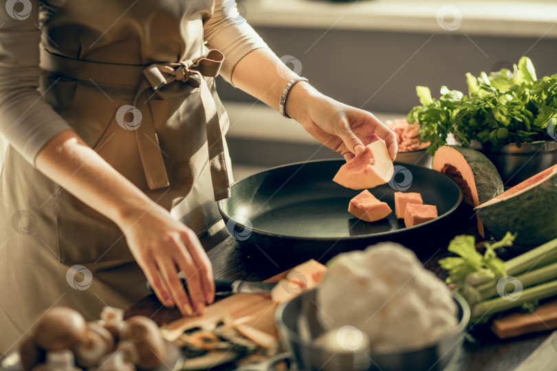 Скачать молодые женщины руками выкладывают тыкву на противень на кухне для запекания. концепция здорового питания фотосток Ozero