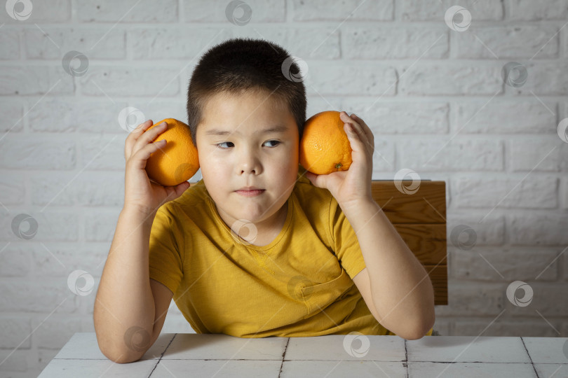 Скачать Маленький ценитель цитрусовых: Наслаждайтесь витамином С в сочных апельсинах фотосток Ozero