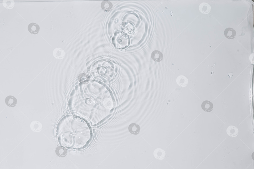 Скачать Абстрактная вода, косметический фон с кольцами, водная гладь. Концепция спа-салона. Косметический увлажняющий крем Splash с мицеллярным тоником или эмульсией фотосток Ozero