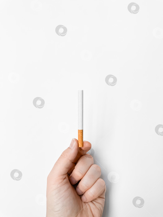Скачать Человеческая рука, держащая сигарету, на белом фоне с пространством для копирования, концепция риска для здоровья. День без табака. фотосток Ozero