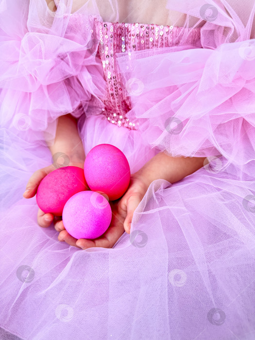 Скачать Девочка в розовом тюлевом платье с ярко-розовыми яйцами в руках - концепция празднования Пасхи в игривой и праздничной атмосфере. Для рекламных материалов, связанных с Пасхой, приглашений на мероприятия, рекламы детских праздников. фотосток Ozero