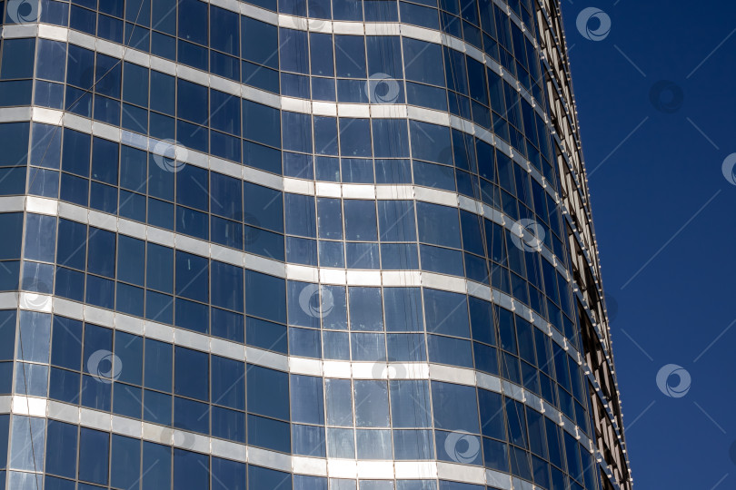 Скачать Возвышающийся небоскреб на фоне ясного голубого неба в городской среде фотосток Ozero