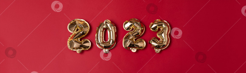 Скачать Позолоченные начинания: В преддверии 2023 года цифры из золотой фольги на красном фоне фотосток Ozero