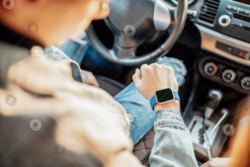 Скачать умные часы на руке водителя автомобиля, крупным планом. концепция транспорта, деловой поездки, технологий, времени и людей фотосток Ozero