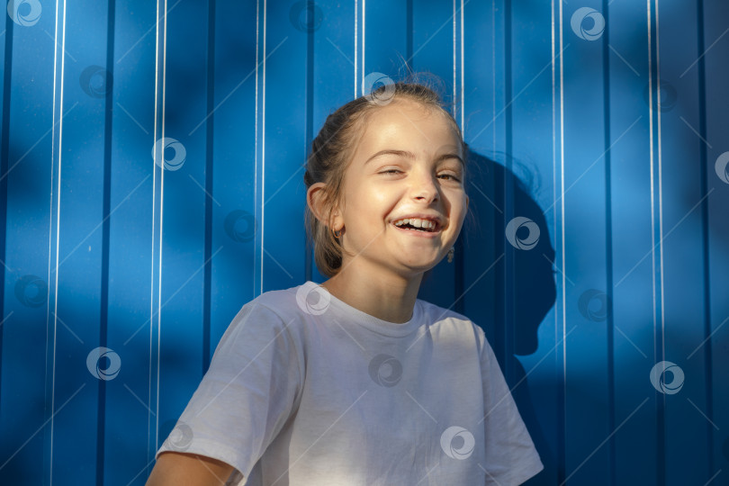 Скачать Безудержная радость: Девичий смех эхом отражается от наружной голубой стены. фотосток Ozero