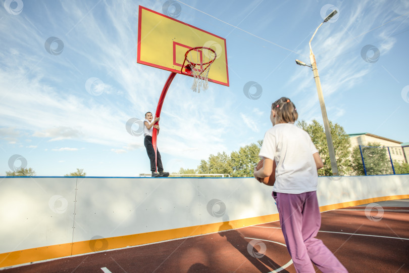 Скачать Игра взглядов: Девушки, увлеченные баскетболом, очарованы смелыми трюками парней с обручем фотосток Ozero