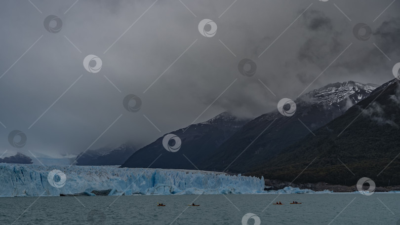 Скачать Стена из потрескавшегося голубого льда возвышается над ледниковым озером. фотосток Ozero