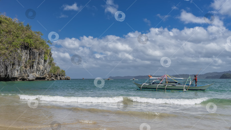 Скачать Традиционная филиппинская лодка-долбленка "бангка" с двумя выносными опорами стоит на якоре у берега. фотосток Ozero