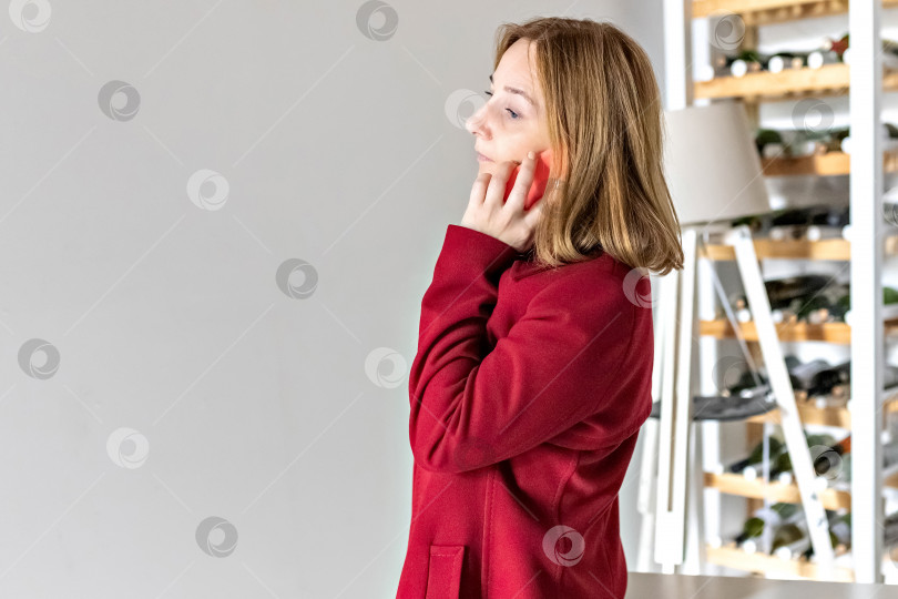 Скачать Симпатичная молодая женщина разговаривает по мобильному телефону в офисе. Бизнес-леди отвечает на звонок со своего смартфона. Деловые переговоры фотосток Ozero