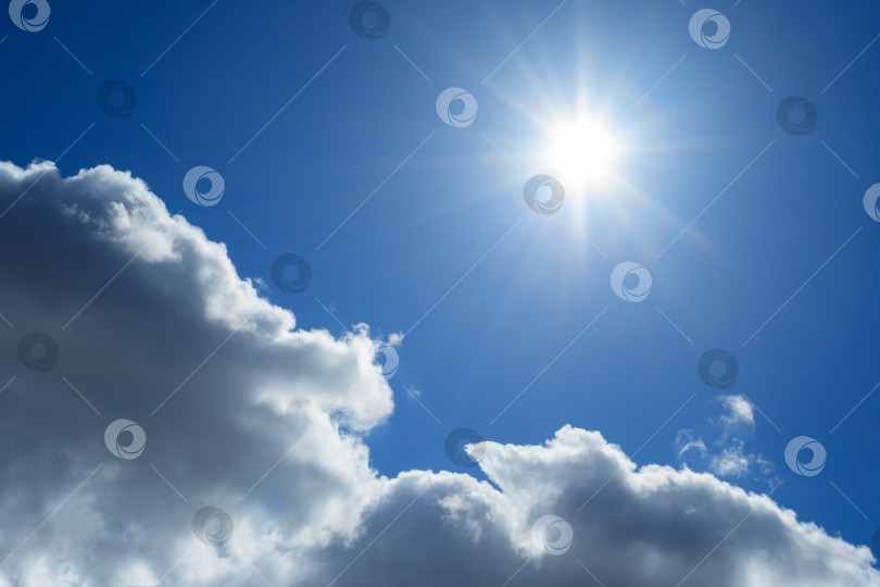 Скачать Крупный план пушистых облаков и солнца в темно-синем небе (задний план) фотосток Ozero