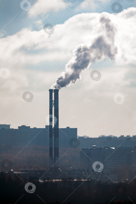 Скачать Дымящиеся трубы на фоне городских домов и облачного неба фотосток Ozero