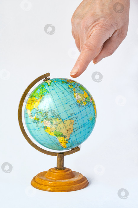 Скачать Женская рука, указывающая на земной шар. Концепция выбора места для отдыха или путешествия фотосток Ozero