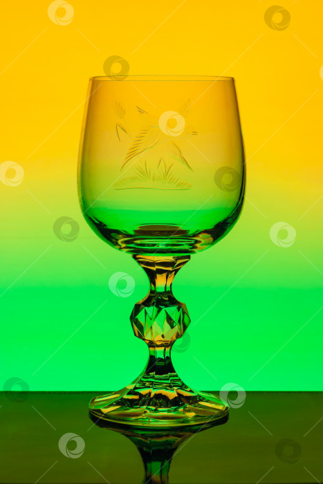 Скачать Хрустальный бокал для вина с выгравированным рисунком на фоне разноцветного градиента фотосток Ozero