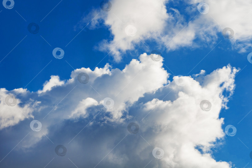 Скачать Белые кучевые пушистые облака на ярко-голубом небе (задний план) фотосток Ozero