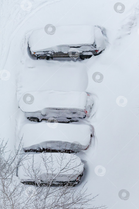 Скачать Машины, занесенные снегом, на парковке. Вид сверху. фотосток Ozero