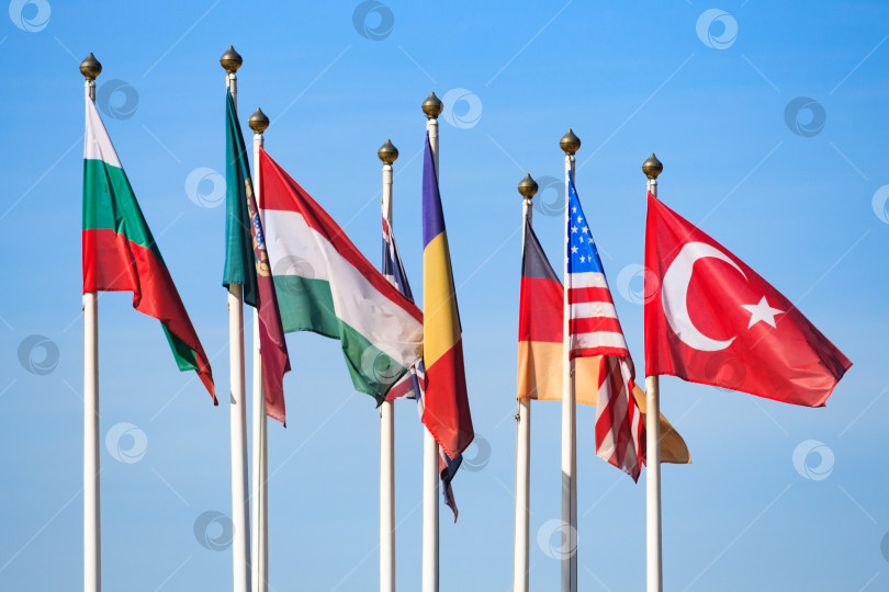 Скачать Флаги разных стран на фоне ярко-голубого неба фотосток Ozero