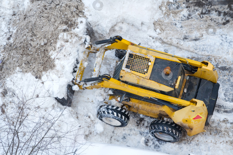 Скачать Вид с высоты птичьего полета на снегоуборочную машину, убирающую снег с дороги фотосток Ozero