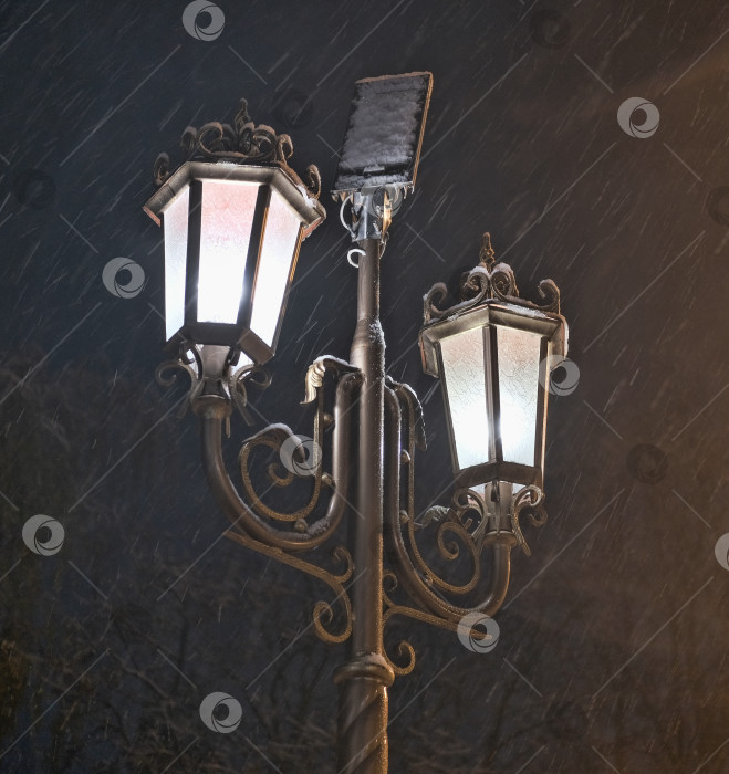 Скачать уличный фонарь ночью зимой во время сильного снегопада фотосток Ozero