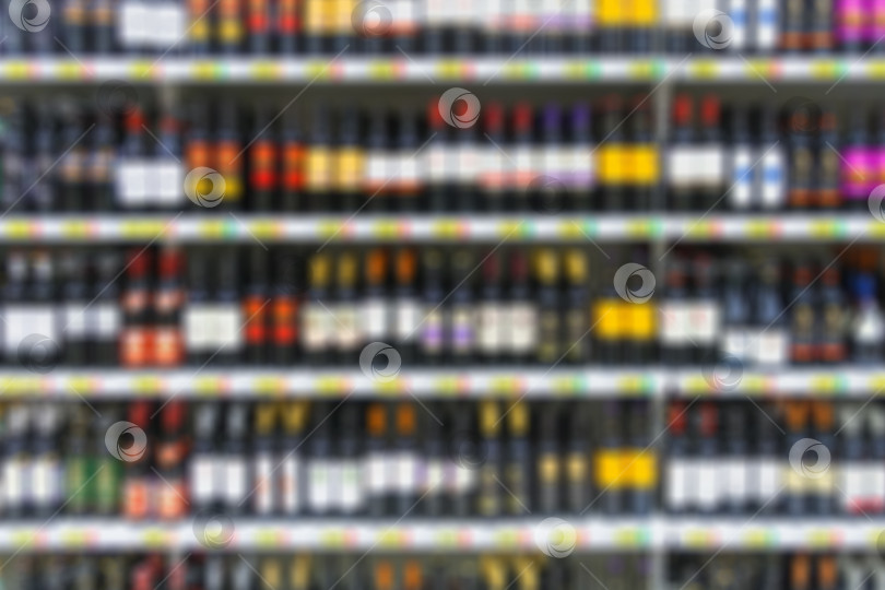 Скачать Алкогольные напитки на полках супермаркета в качестве размытого фона фотосток Ozero