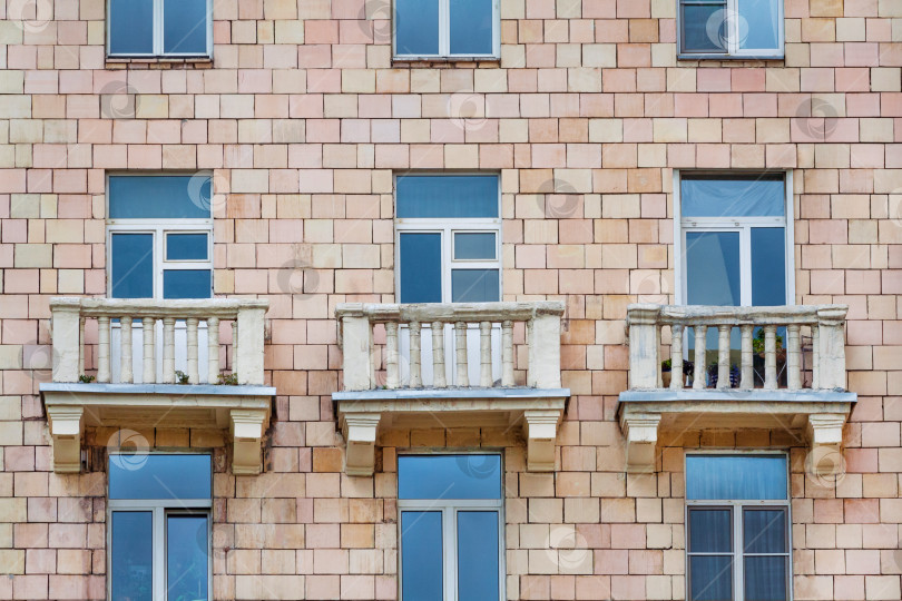 Скачать Вид спереди на фрагмент фасада старого кирпичного жилого дома с тремя балконами (текстура, фон) фотосток Ozero