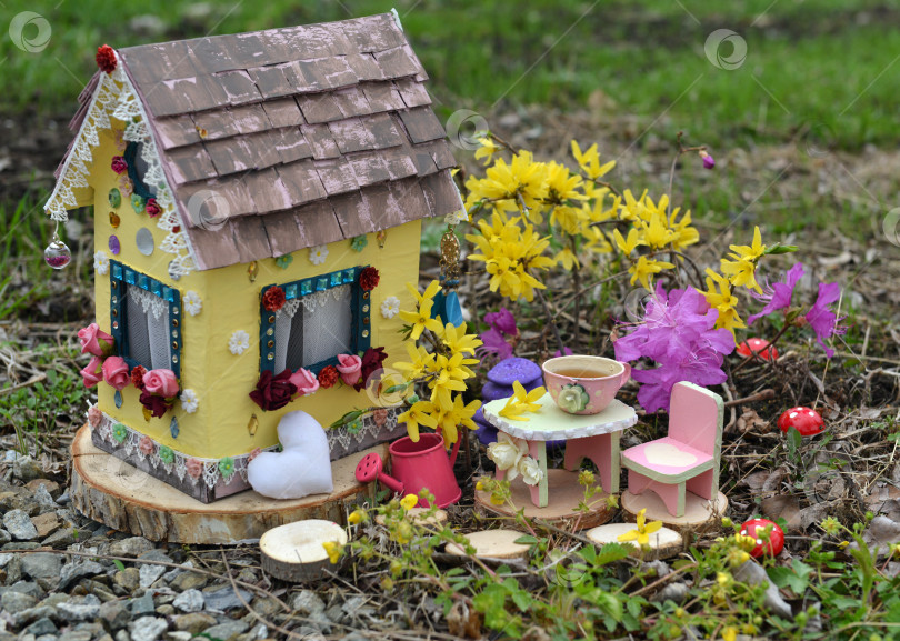 Скачать Милый кукольный домик феи с весенними цветами в саду. Прекрасная миниатюра для поздравительных открыток, оформления свадьбы или дня рождения, недвижимости, сокращения штата, владения домом фотосток Ozero