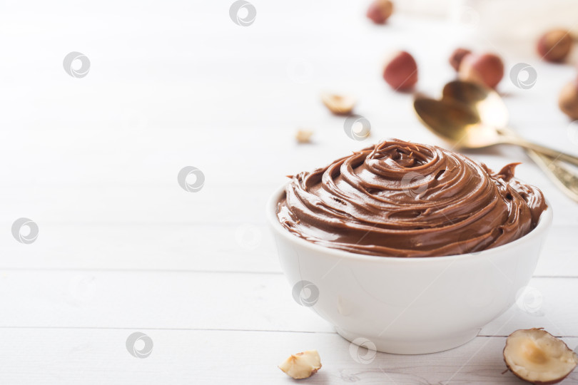 Скачать Шоколадно-ореховая нуга в тарелке на белом фоне с фундуком. Концепция завтрака. Скопируйте пространство. фотосток Ozero