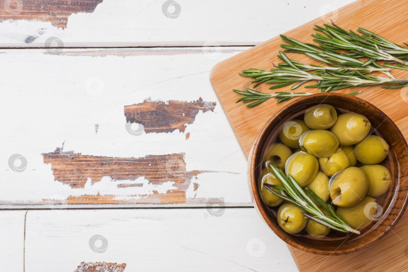 Скачать Зеленые оливки в деревянных вазочках на деревянном столе. Вид сверху с местом для текста. фотосток Ozero