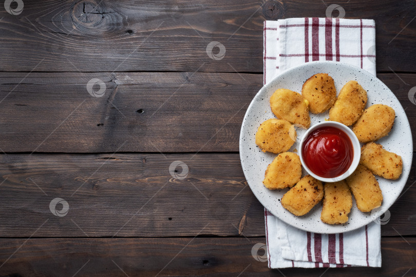 Скачать Жареные куриные наггетсы с томатно-кетчуповым соусом. Деревянный фон. Скопировать пробел. фотосток Ozero