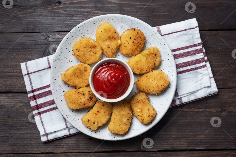 Скачать Жареные куриные наггетсы с томатно-кетчуповым соусом. Деревянный фон. Скопировать пробел. фотосток Ozero