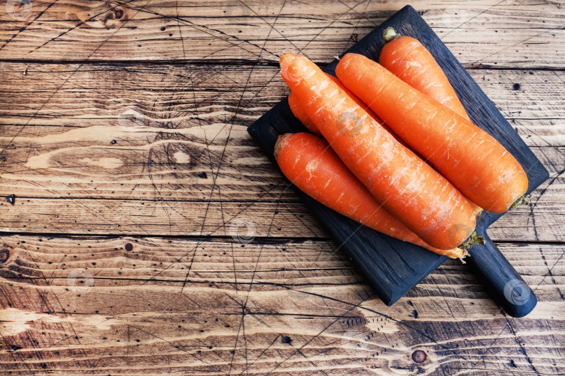 Скачать Несколько сырых морковок на деревянном фоне в деревенском стиле. Скопируйте пробел. фотосток Ozero