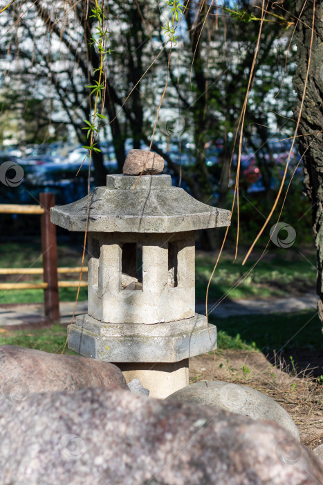 Скачать Каменный фонарь рядом с деревом в парке, украшающий природный ландшафт фотосток Ozero
